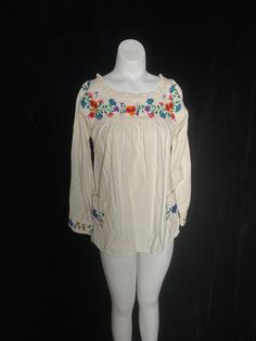 "1970's cream cotton tunic top with colorful embroidered flowers. Great vintage condition, three quarter sleeves Women's small 36\" bust 40\" max waist 24.75\" shoulder to hem 14\" back shoulders" Summer Peasant Top With Multicolor Embroidery And Long Sleeves, Long Sleeve Peasant Top With Multicolor Embroidery For Summer, Folk Style Cream Tops With Floral Embroidery, Embroidered Off White Tops For Spring, Bohemian Off White Top With Floral Embroidery, Off White Embroidered Top For Spring, Folk Style Cream Top With Floral Embroidery, Long Sleeve Embroidered Top For Spring Festival, Cream Embroidered Long Sleeve Top For Spring