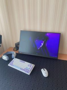 a computer monitor sitting on top of a desk next to a keyboard and mouse pad