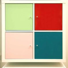 a multicolored cabinet with three doors and four knobs on the bottom shelf