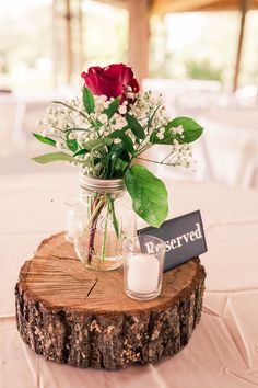 a vase filled with flowers sitting on top of a wooden slice