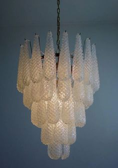 a chandelier made out of glass bottles hanging from a chain in a room