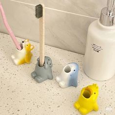 three toothbrush holders sitting next to each other on a bathroom counter