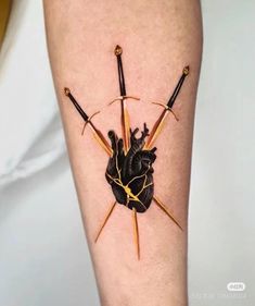 a tattoo on the leg of a person with two sticks sticking out of it's heart