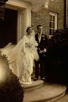 an old photo of a bride and groom standing on the steps