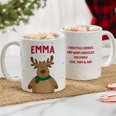 two mugs with hot chocolate in them on a table