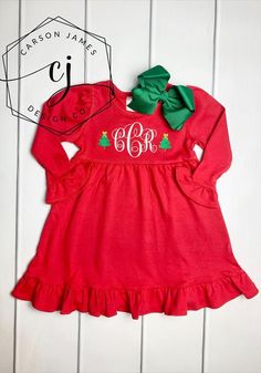 Check out this adorable monogrammed Christmas dress! Perfect for Christmas parties, pictures with Santa, and to wear all season long!The dress has ruffle trim and an empire waist. A white monogram with a Christmas tree on either side is embroidered directly onto the top of the dress using thread. The dress pairs perfectly with out stripped pants (sold separately).To order, first select dress size. Next select pants size and style from the “Add pants?” Box. If you wish to purchase the dress only, Holiday Dresses With Ruffle Hem, White Ruffled Dress For Holidays, Fitted Christmas Holiday Dress With Ruffles, Fitted Holiday Dress With Ruffles For Christmas, Fitted Christmas Dress With Ruffles, Fitted Holiday Dress With Ruffles, Fitted Cotton Christmas Holiday Dress, Fitted Cotton Holiday Dress For Christmas, Holiday Dress With Ruffles For Christmas