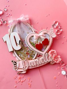 a pink card with the number ten on it and some glitter around it that says danielle