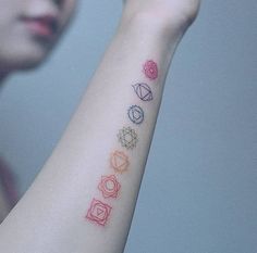 a woman with a tattoo on her arm that has five different colors and shapes in it