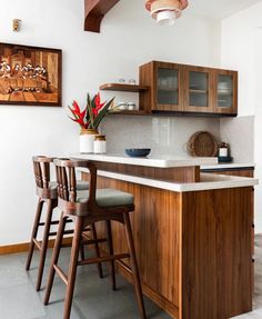 a kitchen with wooden cabinets and stools next to an island counter top in the middle