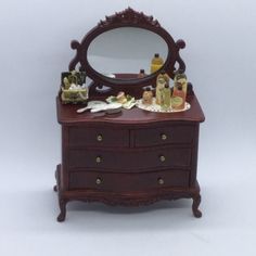 a miniature dresser with a mirror and bottles on it