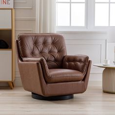 a brown leather chair sitting on top of a hard wood floor next to a window