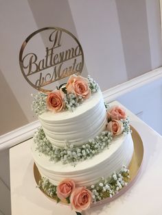 a three tiered wedding cake with flowers on top