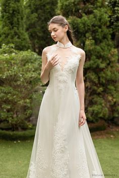 a woman in a wedding dress standing on the grass