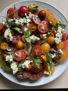 a white plate topped with tomatoes and cheese