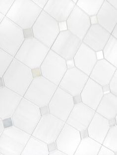 a white tiled wall with hexagonal tiles on it