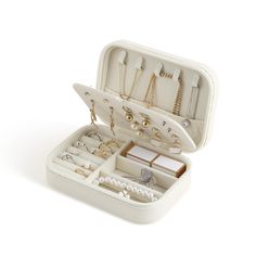 an open white jewelry box filled with lots of different items