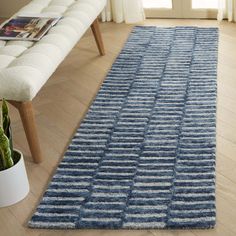 a blue rug on the floor next to a bench