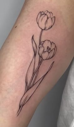 a black and white flower tattoo on the arm