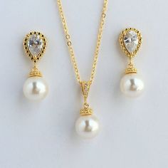 Classic cubic zirconia and pearl bridal  jewelry set in gold plated brass setting includes#Gold tone earrings feature teardrop clear cubic zirconia ear post and 10mm Swarovski pearl dangle drop. Total length of the earrings is 2.7 cms.  #Classic pearl bridal necklace and pendant set with gold plated brass peg and bail.  Necklace features a pendant with 10mm Swarovski single pearl drop that dangles from gold plated brass peg and cubic zirconia bail. Length of the gold plated chain is 18 inches an Formal Pearl Drop Jewelry Sets With Cubic Zirconia, Elegant Pearl Drop Jewelry Set With Cubic Zirconia, Anniversary Jewelry Sets With Pearl Drop And Cubic Zirconia, Classic Gold Crystal Bridal Necklace, Elegant Gold Drop Bridal Necklace, Gold Crystal Bridal Necklace With Pearl Drop, Gold Pearl Drop Jewelry Sets For Anniversary, Gold Pearl Drop Jewelry With Cubic Zirconia, Elegant Gold Drop Jewelry Set