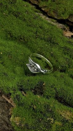 a silver ring sitting on top of green grass