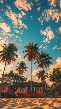 some palm trees and houses on the beach under a blue sky with white fluffy clouds