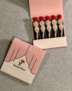 a pink box filled with red and white pins