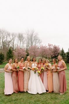 a group of women standing next to each other on top of a lush green field