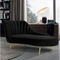 a green chair sitting in front of a window next to a book shelf filled with books