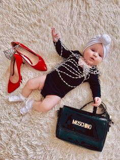 a baby doll laying on top of a rug next to a purse