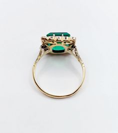 an emerald and diamond ring on a white background