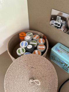 a basket filled with lots of different types of buttons next to a light switch on a wall