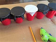 there are many different types of drums in the box and some pencils on the table