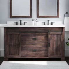 two mirrors are above the double sink vanity in this white and gray bathroom with wood accents