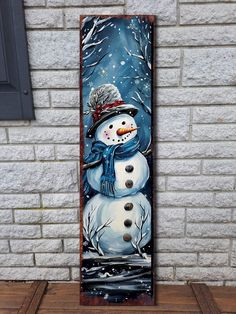 a snowman painted on the side of a brick wall in front of a window