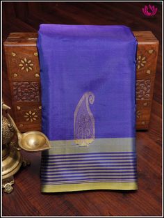 A bananapith silk saree in blue and yellow showcases a delightful fusion of colors. The fabric's luxurious texture elevates the appeal, while mango motifs intricately woven in the body and pallu add a touch of traditional charm. The addition of a striped border enhances the elegance, creating a balanced and visually appealing ensemble. This type of saree is perfect for those seeking an elegant and sustainable fashion choice. Hand-woven saree. Fall & pico - done Tassels on pallu Blouse piece - no Blue Slub Silk Saree For Festivals, Blue Tussar Silk Blouse Piece For Wedding, Blue Slub Silk Blouse With Zari Weaving, Blue Slub Silk Blouse Piece For Festivals, Blue Elegant Traditional Wear For Puja, Blue Tissue Silk Saree With Pallu, Blue Tissue Silk Saree With Pallu Detail, Blue Slub Silk Saree In Traditional Drape, Blue Handloom Tissue Silk Blouse Piece