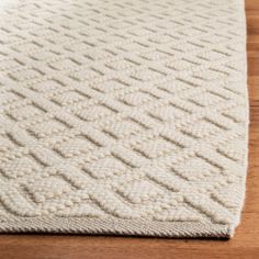 a white rug on top of a wooden floor