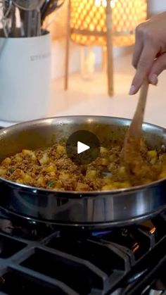 a person stirring food in a pan on the stove