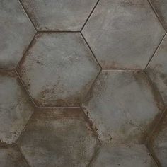 a close up view of a cement wall with hexagonal tiles on the floor