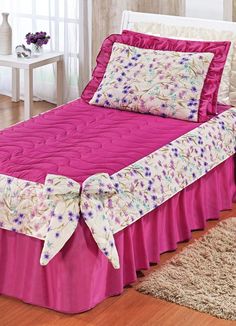 a bed with pink bedspread and matching pillowcases in a bedroom setting