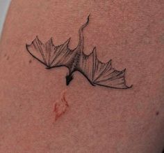 a black and white photo of a leaf on the side of a woman's thigh