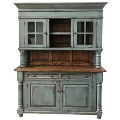 an old blue hutch with wooden top and doors on the front, isolated against a white background