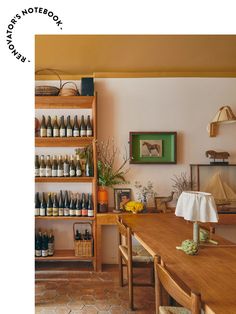 a wooden table sitting next to a shelf filled with bottles