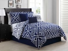 a bed with blue and white comforters in a room