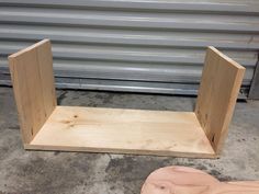 a wooden shelf sitting on top of a cement floor