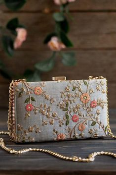 "Our Floral creeper clutches are super-hot, year-round! The traditional silhouette with exquisite floral embroidery and the metal chain sling are perfect to add that oomph to your overall look and make a strong style statement, no matter what the occasion. Embroidered front and back. Dimensions (LxB): 8\"x4.5\" Handle length: 47\" Handle drop: 23\" Material: Embroidered poly silk, poly satin lining, gold metal clutch frame, gold metal sling. Features: metal lock closure, detachable metal sling" Fancy Clutch, Personalized Clutch, Bridal Boxes, Hand Bags For Women, Clutch Bag Wedding, Embroidered Clutch, Potli Bags, Fancy Bags, Box Clutch