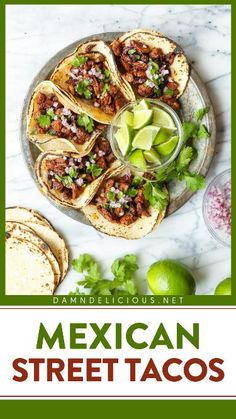 mexican street tacos on a plate with limes and cilantro