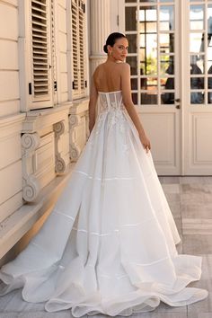 a woman in a white wedding dress standing outside