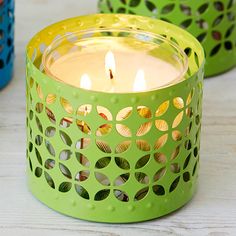 two green and yellow candles sitting on top of a table