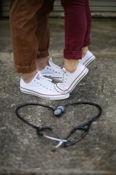 someone standing on top of a pair of white shoes