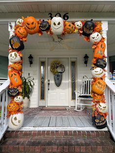 a front porch decorated for halloween with pumpkins and jack o lanterns